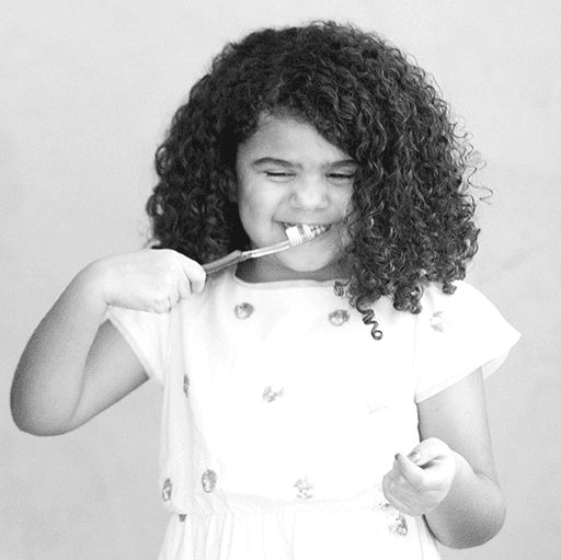Child brushing teeth with a big smile at Balster and Pfohl